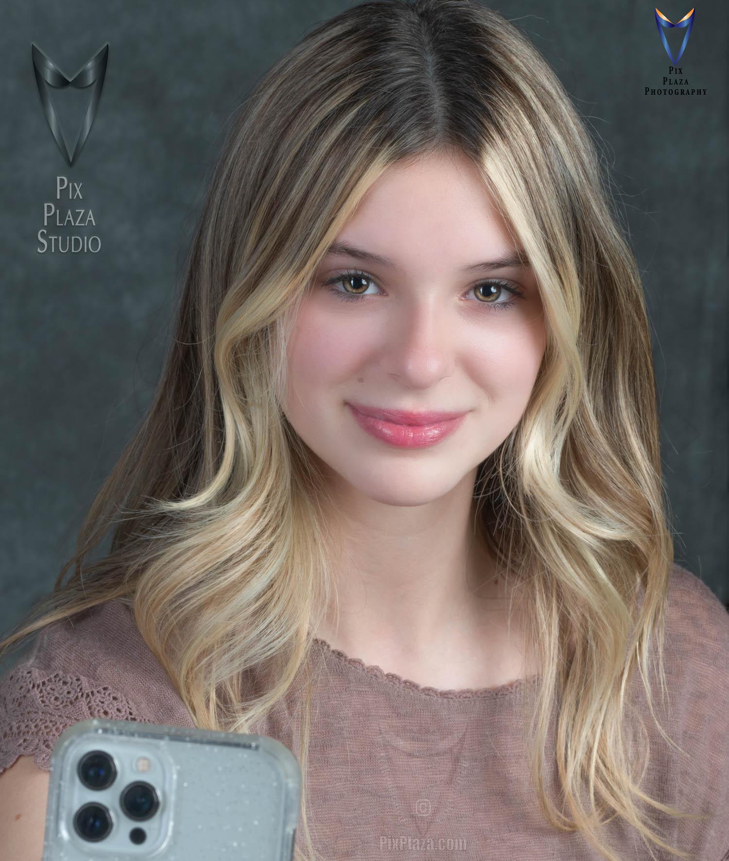 Teen girl taking a selfie with white iPhone pro max