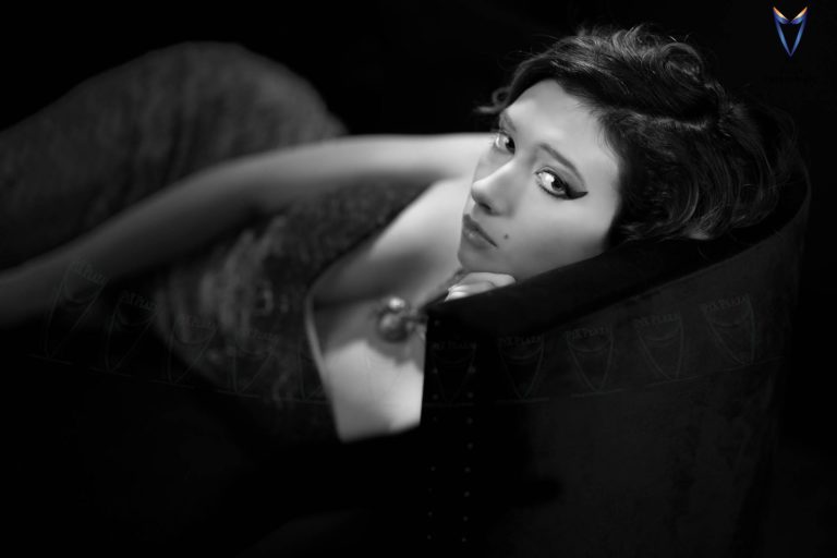 Young girl lying on sofa and looking at camera in black and white photo